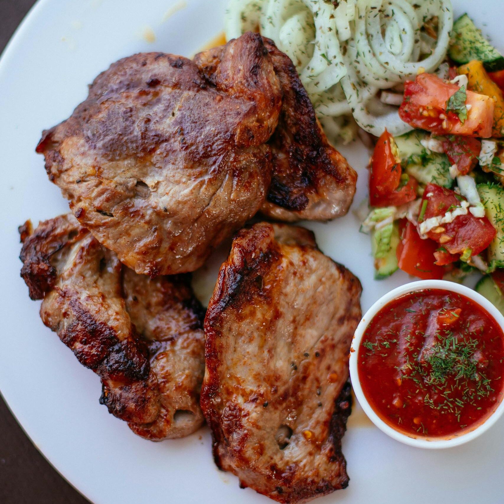Juicy grilled pork chops served with a fresh salsa and crispy salad.